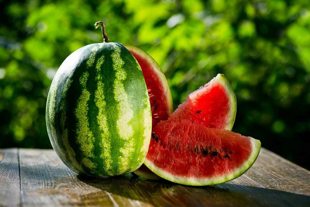 Fresh sliced watermelon wooden background, Ripe striped watermelon, Close-up of fresh slices of red watermelon, sweet harvest. Watermelon pattern. Watermelon background.